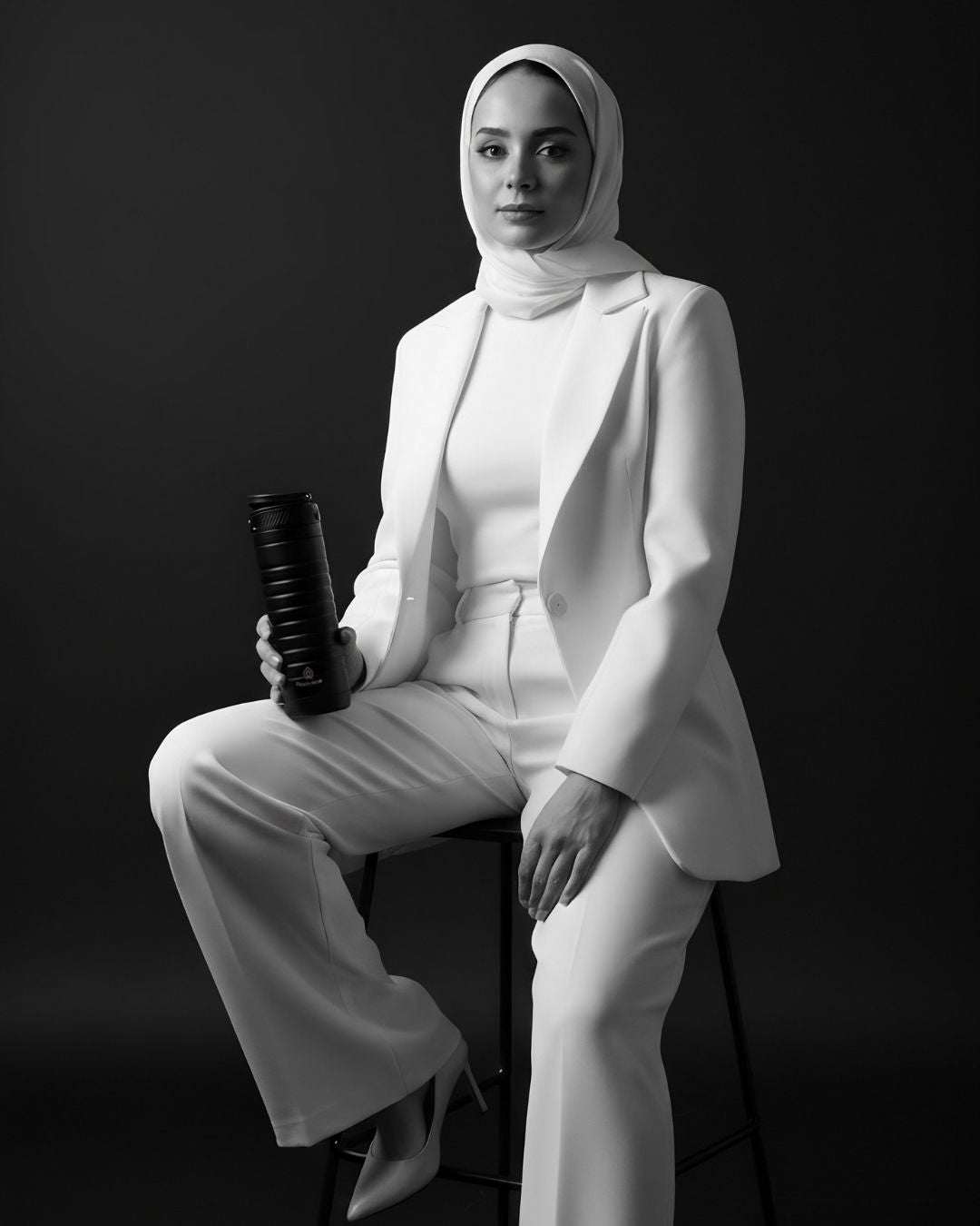 Black-and-white portrait of a woman holding a Rooveco tumbler, representing the brand’s story.