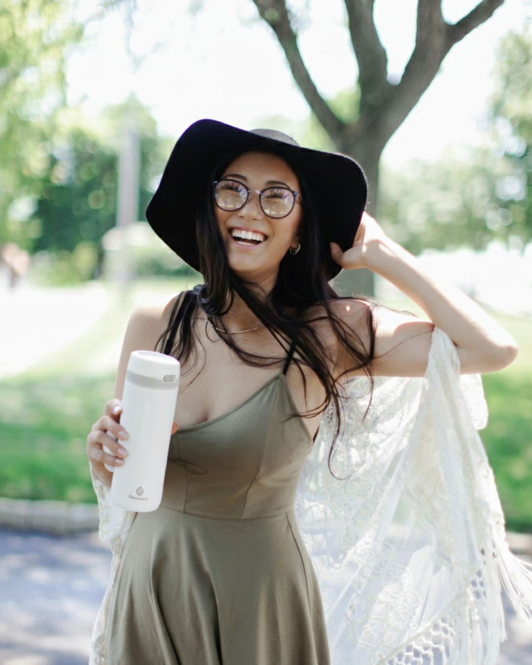 Lifestyle photo of a woman holding a white Rooveco bottle outdoors, symbolizing the brand’s vision and future direction.